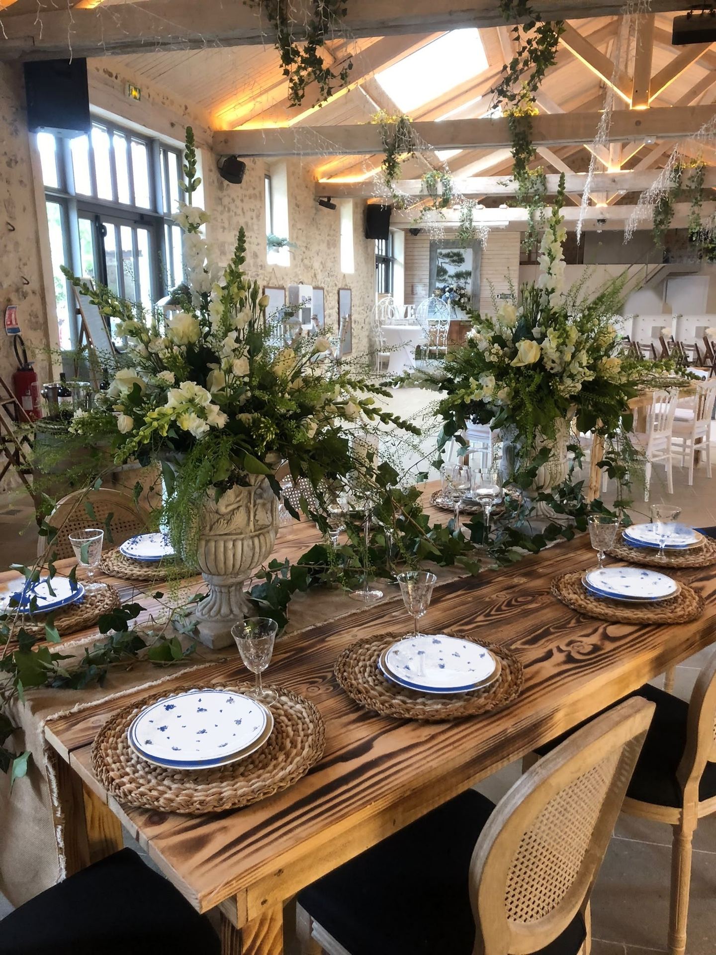 Table de mariage dans une grange aux poutres apparentes, vaisselle en porcelaine bleue